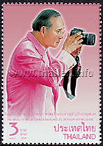 King Bhumipon Adunyadet in a pink blazer and holding his camera